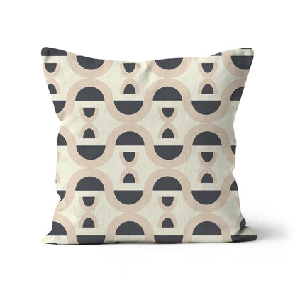 Square-shaped cushion covered with a graphic repeat pattern of beige loops and black half circles against a pale cream background.