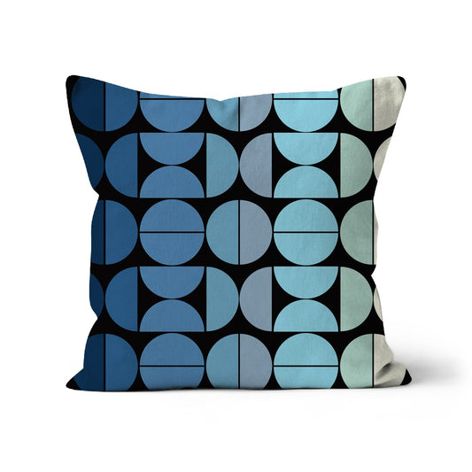 Square shaped cushion with Bauhaus style graphic pattern in graduating colours from black to pale blue and cream shades.
