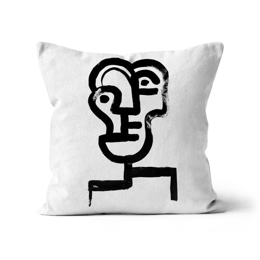 Cushion with primitive ink drawing of a contemporary abstract  face against a white background