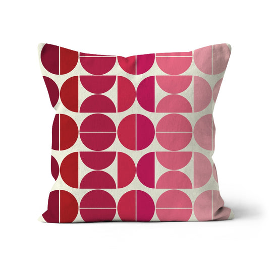 Square shaped cushion with Bauhaus style graphic pattern in graduating shades of pink.