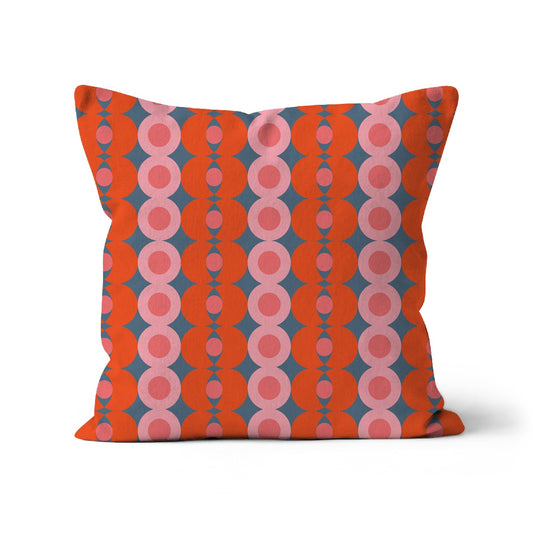 Square shaped cushion with Bauhaus style pattern. Orange & pink graphic pattern against a dark grey background.