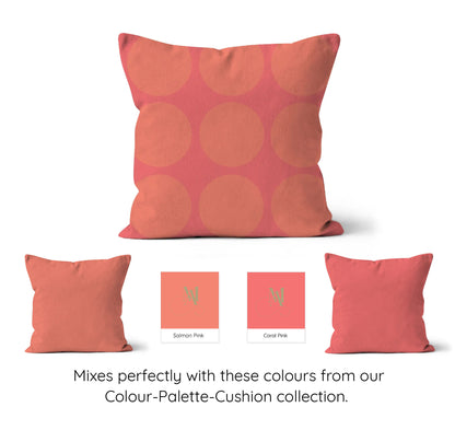 Square cushion with salmon pink spotty graphic with a coral pink background.