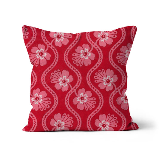 Square shaped cushion featuring pink flowers and wavy line pattern on a red background. 
