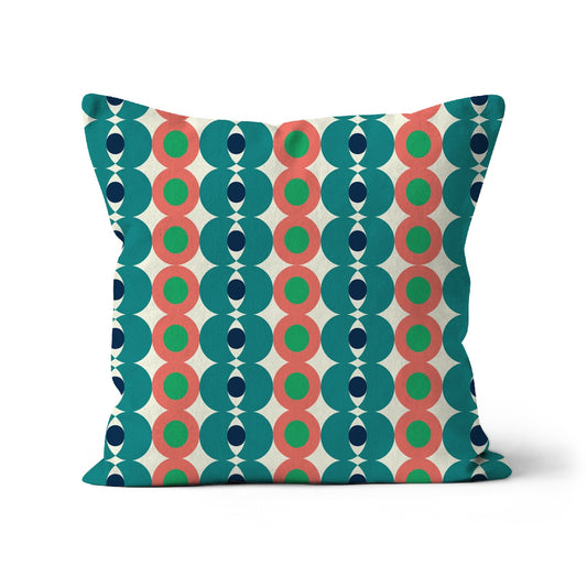 Square shaped cushion with Bauhaus style pattern. Teal, dark blue salmon pink and  jade green geometric shapes circles on a cream background.