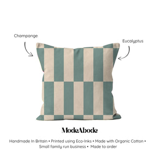 Checkered pillow with green and beige stripes on a white background, labeled 'Champagne' and 'Eucalyptus', with ModeAbode branding.