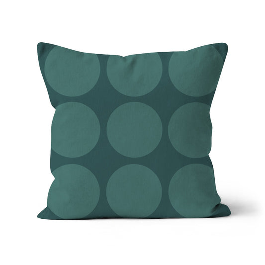 Square shaped cushion with large grey green spots on a dark green background.