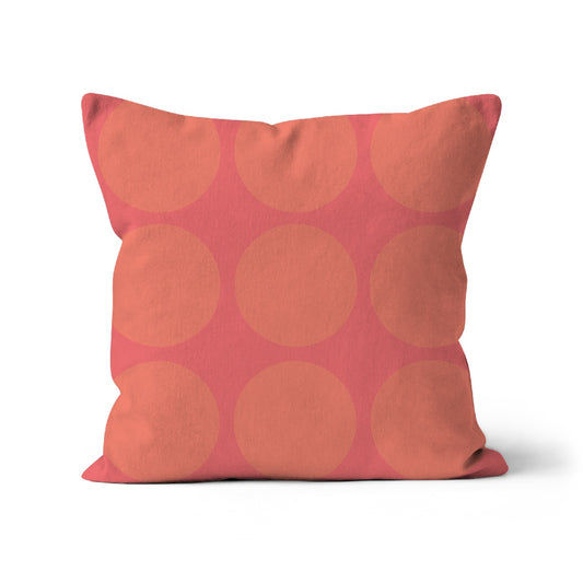 Square shaped cushion with large peach spots on soft pink background.