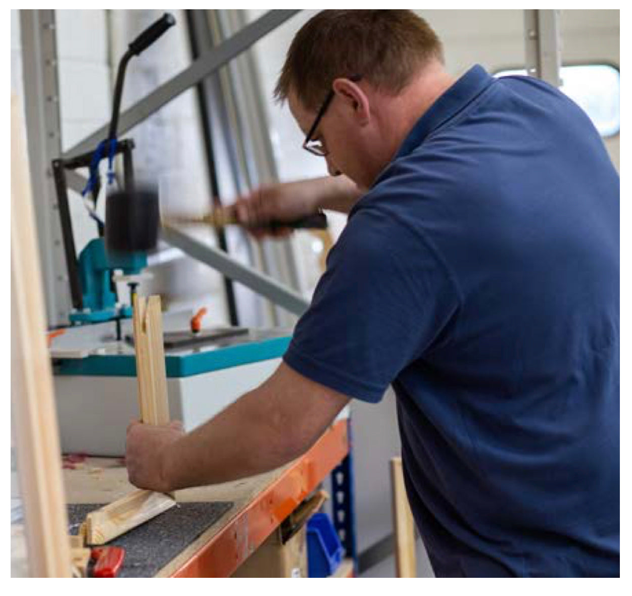 British craftsman in workshop making a wooden picture frame.